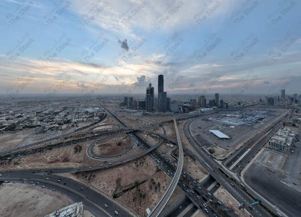 لقطة جوية للأبراج مركز الملك عبدالله المالي في العاصمة الرياض وتظهر السماء غائمة اثناء الغروب، حركة المرور في مدينة الرياض