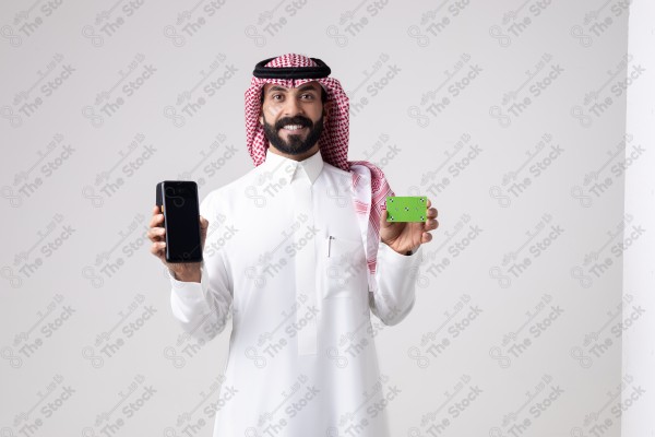 Portrait of a Saudi man holding an automatic payment device and a card and making different expressions