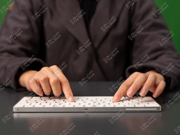 A person typing on a white keyboard.