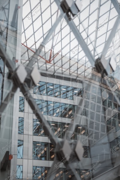 A view of the interior level of a facility with modern architectural design, featuring a glass roof showcasing a grid pattern.