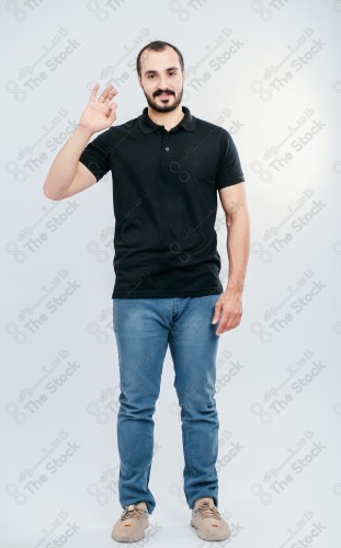 Portrait of a Saudi man on a white background making hand gestures while smiling, souvenir photos, documenting a happy moment