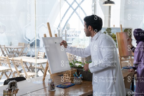 A group of Saudi people draw one of the paintings in the drawing lab