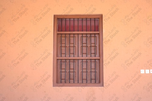 Detail of an old wooden window in a mud wall, decorative wooden window.