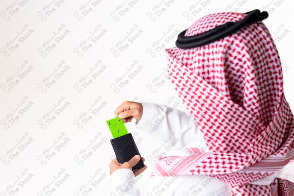 بورتريه رجل سعودي يحمل بطاقة خضراء على خلفية بيضاء