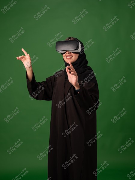 امرأة ترتدي نظارة واقع افتراضي وتبتسم بينما تتفاعل مع المحتوى الافتراضي على خلفية خضراء.