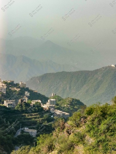 صورة لمشهد طبيعي من محافظة فيفاء بمنطقة جازان جنوب المملكة العربية السعودية في منطقة جبلية مرتفعة مغطاة بالخضار. تظهر قرية صغيرة, مبنية بمنازل تقليدية متراصة بين التلال الخضراء, وفي الخلفية تبدو سلسلة جبال مغلفة بالضباب.
