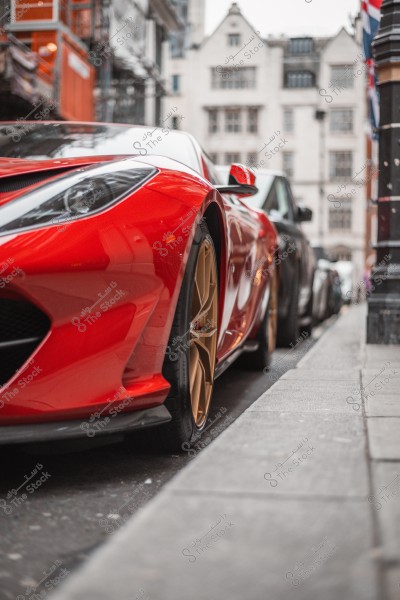 A shiny red sports car parked on the side of a city street, with historic buildings in the background.