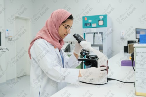 Saudi doctor in a hospital works in a laboratory, a medical team uses a microscope to examine a blood sample, and works in the field of health, providing medical consultations and medical health services.