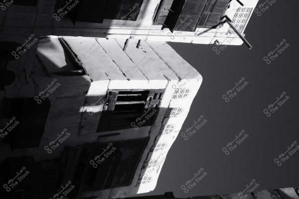 صورة بالأبيض والأسود لواجهة مبنى قديم بملامح معمارية تقليدية, تظهر فيها فتحات تهوية وزخارف هندسية.