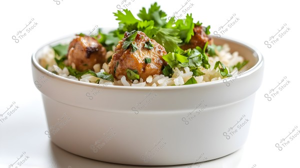A white bowl containing white rice topped with small meatballs and fresh parsley. The rice appears fluffy and well-cooked. The meatballs are golden and well-seasoned, giving the dish an appetizing look. The fresh green leaves add color and freshness to the dish.