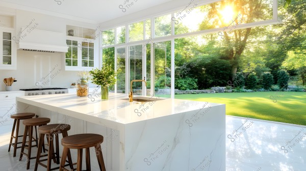 A modern kitchen with a large white island and marble countertop, surrounded by wooden stools. There is a copper sink and faucet on the island. Behind the kitchen is a large glass window overlooking a bright, green garden with trees and shining sun.