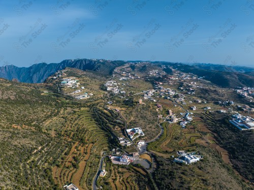 لقطة للمناظر الطبيعية في مدينة ابها تظهر فيها المباني والمعالم ، السماء ملبدة بالغيوم وقت النهار.