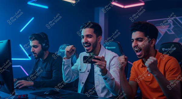 Three men are sitting side by side in a room illuminated with blue and pink neon lights. The first man on the left is wearing a headset and using a personal computer, while the other two appear cheerful with their fists in the air. The person in the middle is holding a smartphone and wearing a white jacket, and the person on the right is wearing an orange shirt.