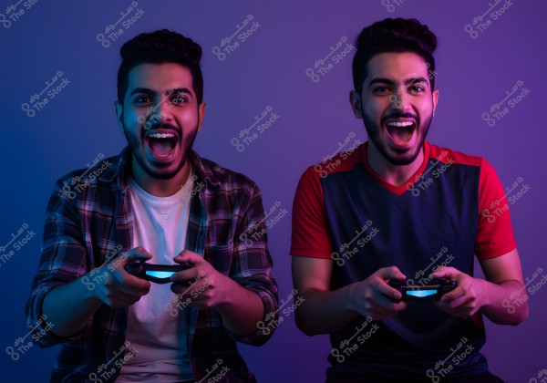 The image shows two young men sitting side by side, each holding a video game controller. They appear excited and joyful. The young man on the left is wearing a checkered shirt over a white T-shirt, while the young man on the right is wearing a short-sleeved T-shirt in red and black. The background is lit with soft purple and blue tones, giving the image a festive atmosphere.