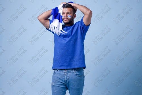 A Saudi young man wearing a blue T-shirt with facial expressions and hands indicating sadness, World Cup