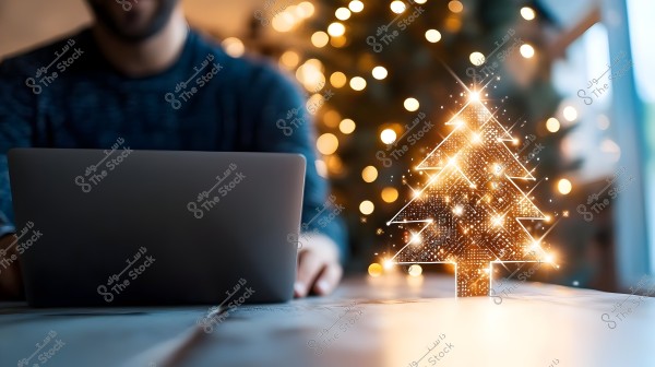 An image of a person sitting in front of a laptop with a glowing Christmas tree beside them. The background features warm, colorful Christmas lights creating a festive atmosphere.