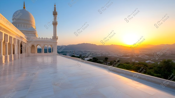 A sunset view behind an ornate white mosque featuring a dome and a minaret. A marble floor extends across the image, accompanied by a landscape of cityscapes and mountains on the horizon under a clear blue sky.