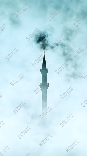 Image of a tall minaret tower rising above thick fog. The tower has a slender, elongated design with traditional Islamic architectural details. The surroundings are misty and enchanting with a pale blue tone.