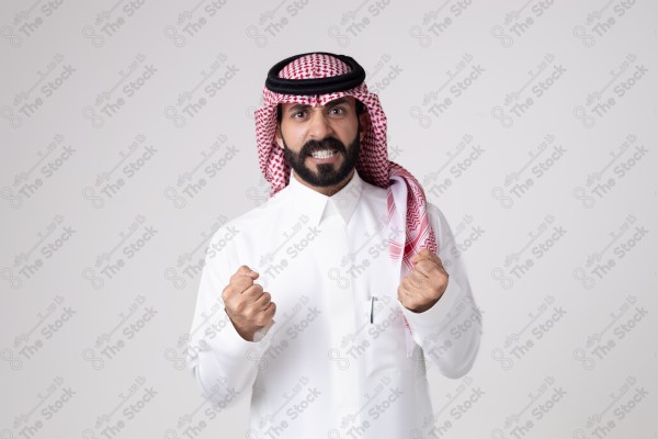 بورتريه رجل سعودي يقف على خلفية بيضاء ويعبر عن غضبة