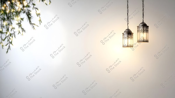 الصورة تحتوي على فانوسين مضاءين مصنوعين من المعدن بتصميم مزخرف يتدليان من السقف بسلاسل طويلة. الفوانيس تضيء جدارًا فاتح اللون بخلفية هادئة. في الزاوية اليسرى العلوية, تظهر بعض الفروع الخضراء المعلقة المزينة بأضواء صغيرة تضيف لمسة احتفالية إلى المشهد.