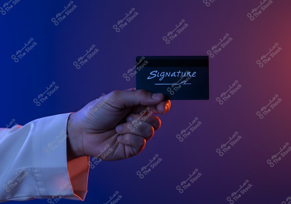 A person\'s hand holding a black card with \"Signature\" written in white. The hand is wearing a white shirt, and the lighting is dual-toned with blue on the left and red on the right, creating a visual contrast in the image.