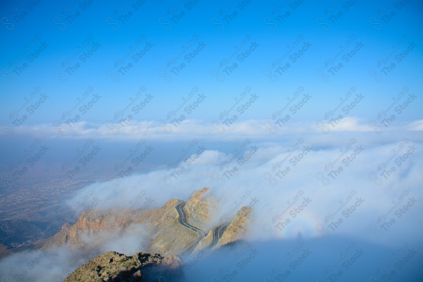 An aerial shot of a series of tall rocky mountains, showing the sky overcast, nature in Saudi Arabia.