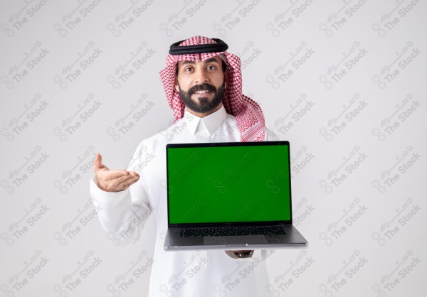 Portrait of a Saudi man holding a laptop, pointing at the laptop and making different expressions - green screen