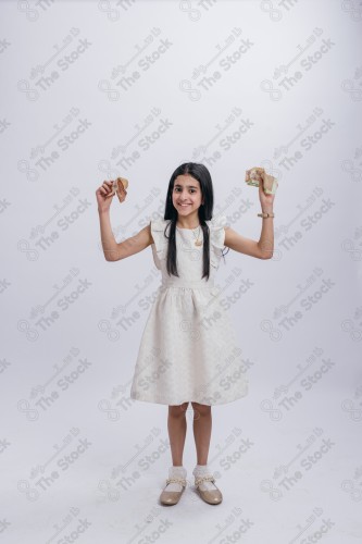 Portrait of a Saudi girl on a white background making gestures with her hands while smiling, souvenir photos, documenting a happy moment, Eid candy, Eid gifts, Eidiyat