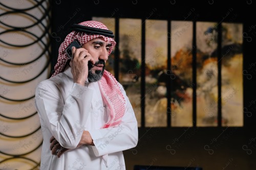 رجل سعودي  يقوم بتفاعلات مختلفة باستخدام الجوال