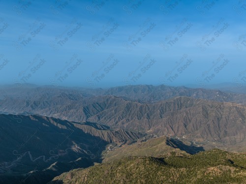 لقطة جوية للمناظر الطبيعية في مدينة ابها تظهر فيها المباني والمعالم، ،السماء ملبدة بالغيوم وقت النهار.