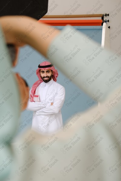 بورتريه شابة سعودية محجبة ترتدي العباءة تحمل الكاميرا وتقوم بالتقاط صور داخل استديو، معدات تصوير .