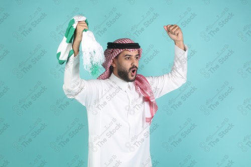 شاب سعودي يرتدي الزي السعودي ممسك شال بيده بتعابير وجه و يدين تدل على السعادة والحماس ، كأس العالم