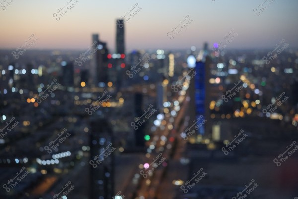 صورة غير واضحة للمدينة في وقت المساء حيث تظهر الأضواء والعديد من المباني الشاهقة. الأضواء تتلألأ بألوان مختلفة بينما تملأ المدينة الأفق تحت سماء الشفق.