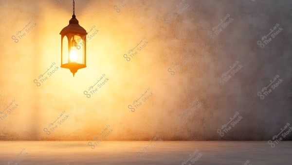 A lit lantern with a traditional design hanging on a light brown wall. The lantern casts a warm glow on the surrounding wall, creating a calm and cozy atmosphere.