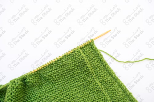 Close-up of a green textile for knitting clothes on a white background, fabrics and textures.