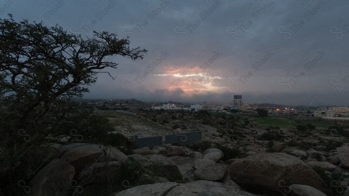 السماء و الغيوم المتفرقة تظهر فيها المباني والمعالم على مدينة أبها في المملكة العربية السعودية.