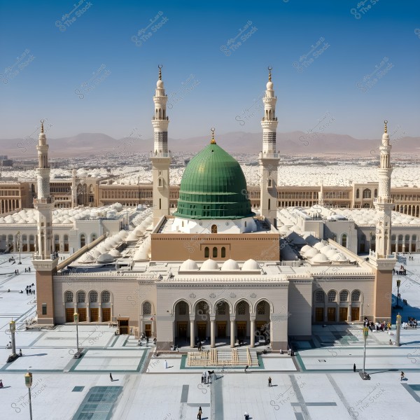 The image shows the Prophet\'s Mosque in Medina, Saudi Arabia. The iconic green dome of the mosque is featured prominently in the center, surrounded by four minarets. The outer courtyard is spacious with several people gathered. The buildings in the background provide a comprehensive view of the vast mosque.