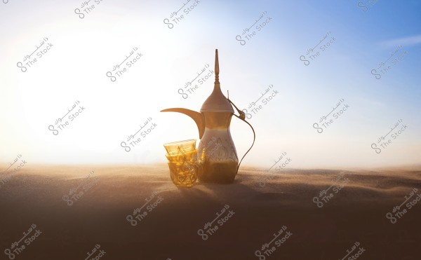 A traditional Arabic coffee pot made of decorated metal, placed on the desert sands. Next to it, there are two glass cups with decorative designs. The background features a blue sky with a bright sun above the horizon.