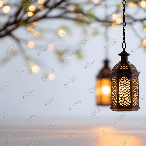 Two traditional lanterns hanging in the air, emitting a warm light reflecting on the surface below. There are small circular lights in the background, suggesting hints of tree branches and leaves.