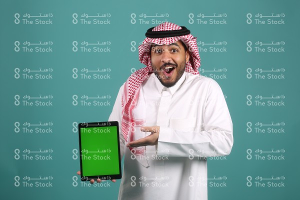 تفاعل شاب سعودي للجهاز اللوحي ويرتدي الزي السعودي