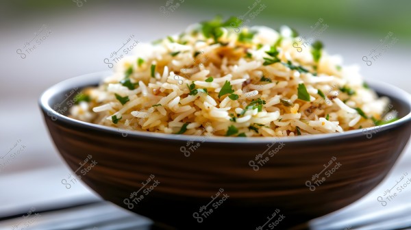 An image of a bowl of rice served in a brown dish. The rice is fluffy, and there are fresh green herbs, such as cilantro or parsley, sprinkled on top, giving it an appetizing appearance. The background is blurred, with the focus on the rice.