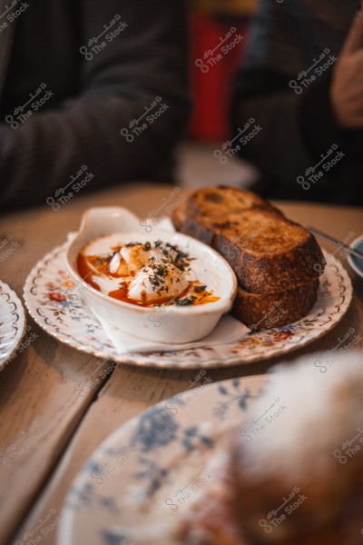 A dish containing poached eggs served with a red sauce, accompanied by slices of toasted bread.