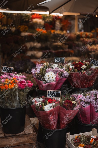 Colorful flower bouquets for sale in a market, each with a price tag of £20.
