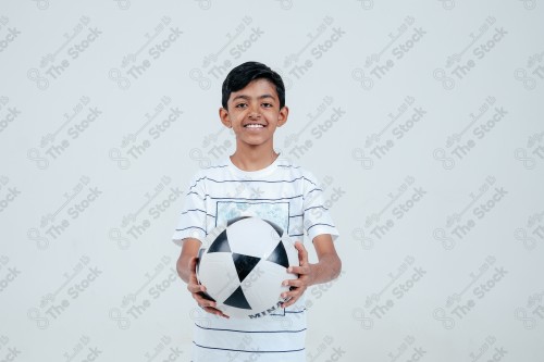 Saudi Boy holding a soccer ball on a white background, a soccer game.