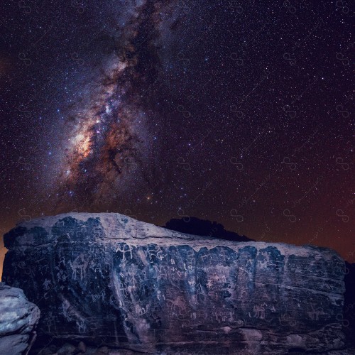 Night shot of a sparkling rock in the middle of the desert. He called it the stars and meteors of the Milky Way.