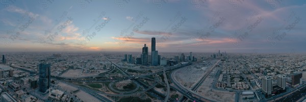 لقطة جوية للأبراج مركز الملك عبدالله المالي في العاصمة الرياض وتظهر السماء غائمة اثناء الغروب، حركة المرور في مدينة الرياض