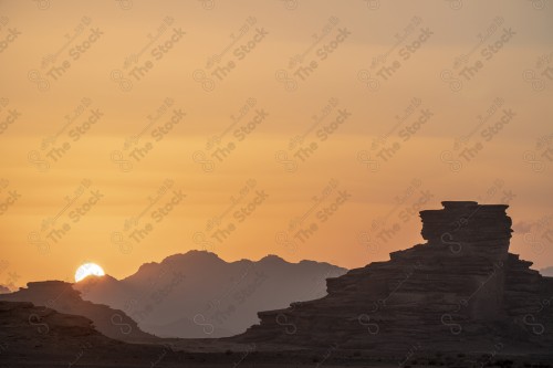 لقطة جوية درون لسلسلة من الجبال في تبوك وقت غروب الشمس، سماء صافية.