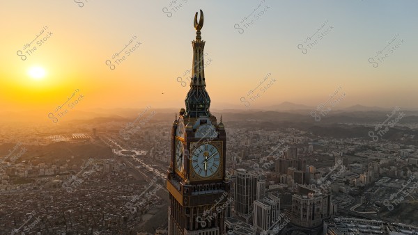Aerial view of the Clock Tower in Mecca, Saudi Arabia, during sunset. The tower is prominently featured with its large clock faces and a golden crescent at the top. Surrounding buildings and mountains are visible in the background under a sky painted with warm sunset colors.