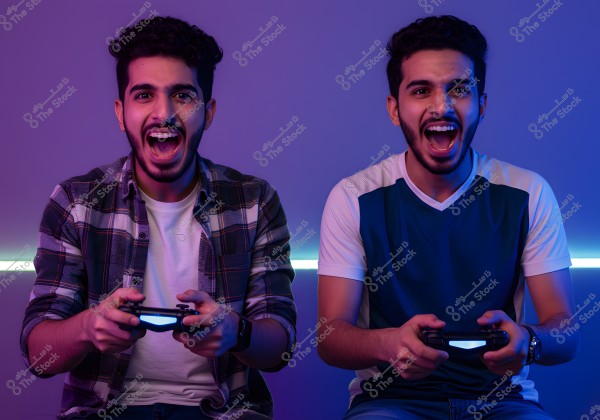 The image shows two young men sitting side by side, appearing enthusiastic as they play video games. Both are holding controllers in their hands. The person on the left is wearing a white shirt under a checkered shirt, while the person on the right is wearing a blue shirt with white sleeves. The blue backlighting adds an exciting atmosphere to the image.
