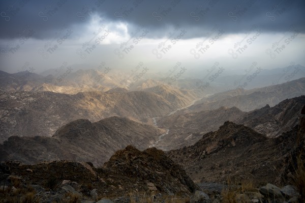 لقطة جوية لسلسلة من الجبال والطرق الوعرة الممتدة بالجبل في مدينة الطائف وتظهر السماء غائمة، جبال، صخور.